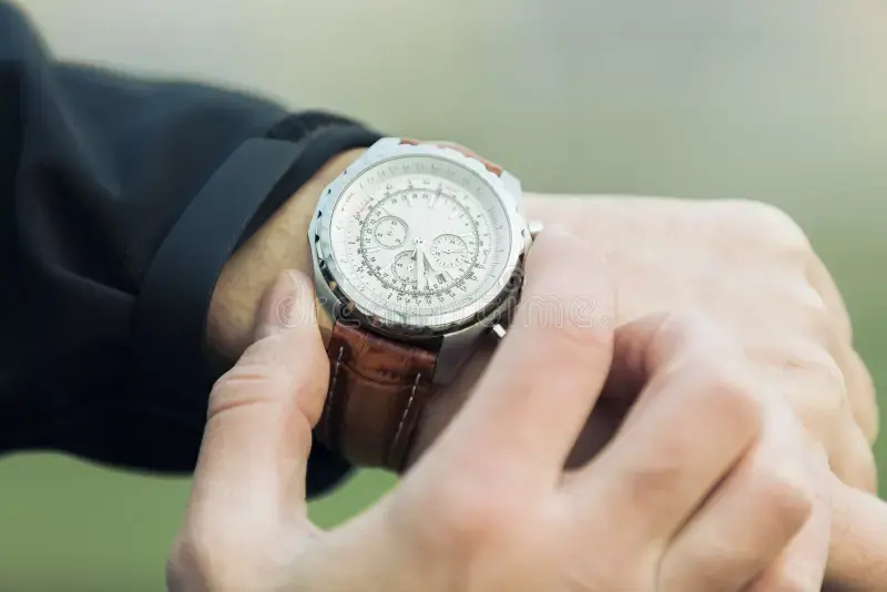 man-hand-elegant-expensive-watch-leather-brown-strap-background-green-blurred-natural-green-color-park-63652936